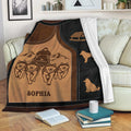 Sledding throw blanket draped over a couch with a dog team, mountain scene, and sled artwork