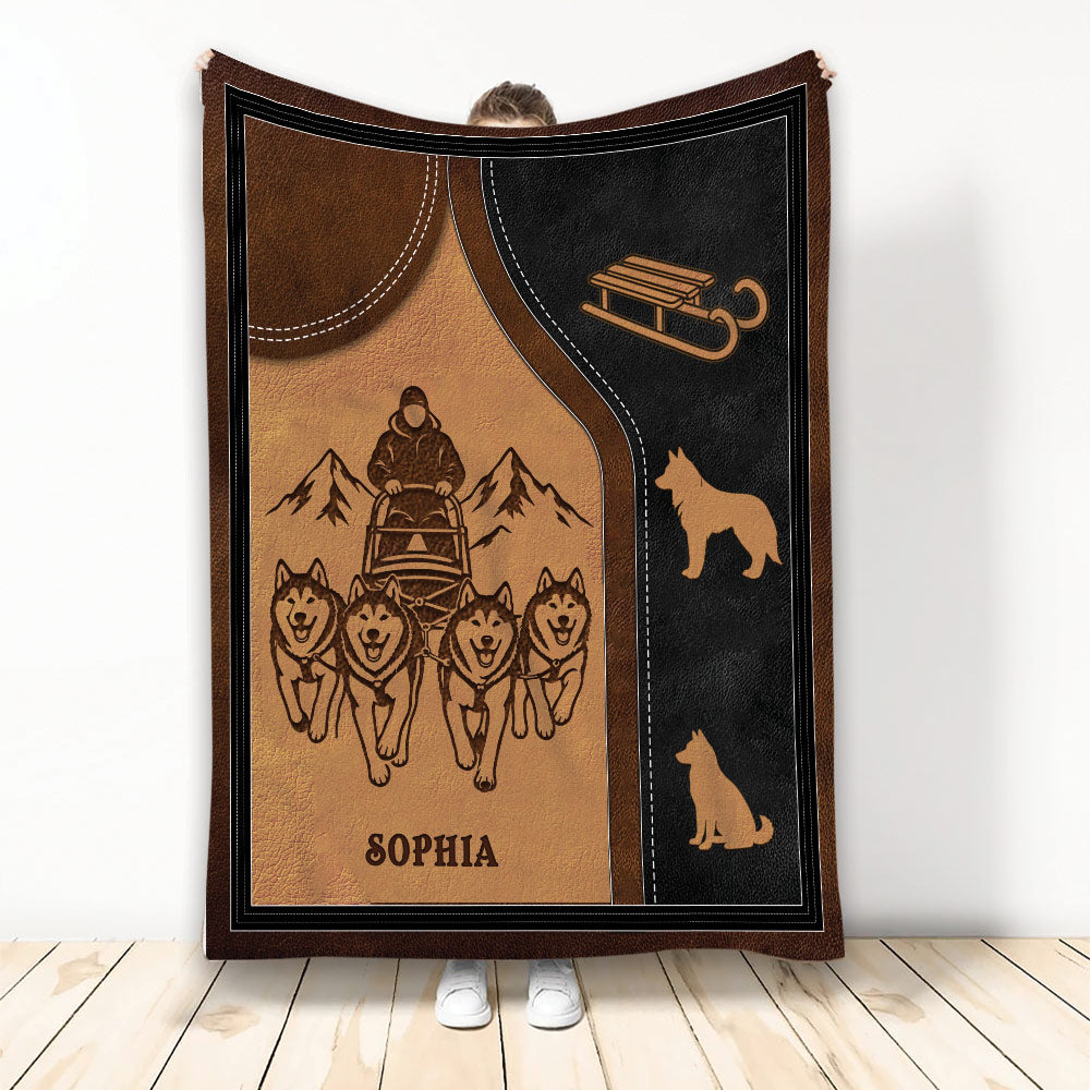 Sledding blanket with a musher, team of dogs, mountain artwork, and rustic brown and black design