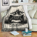 ATV throw blanket displayed on a sofa with bold black and cream quad rider artwork