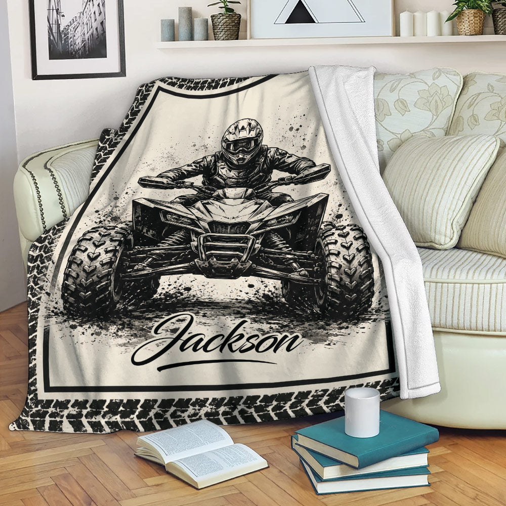 ATV throw blanket displayed on a sofa with bold black and cream quad rider artwork