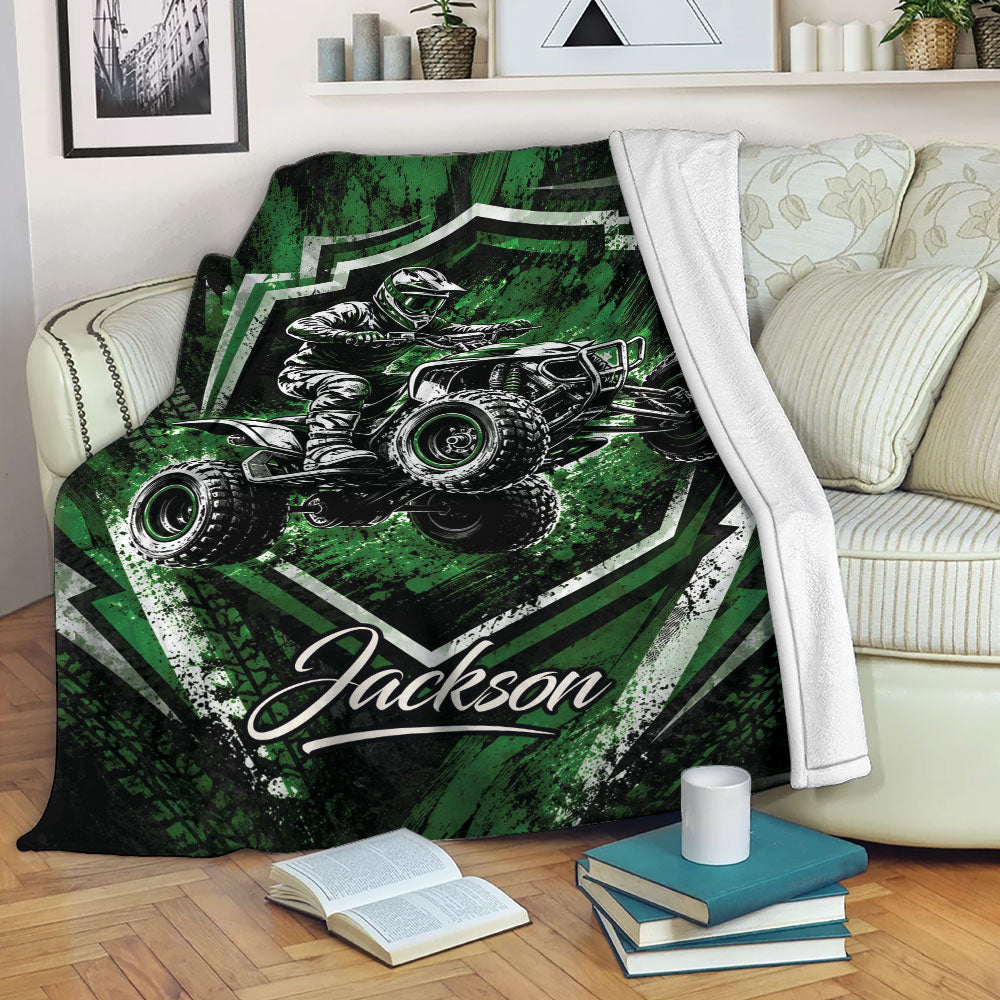 Green ATV throw blanket displayed on a sofa with an off-road quad rider and rugged graphic artwork