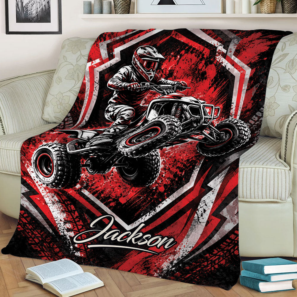 Red ATV throw blanket draped over a sofa with a helmeted quad rider and bold geometric artwork