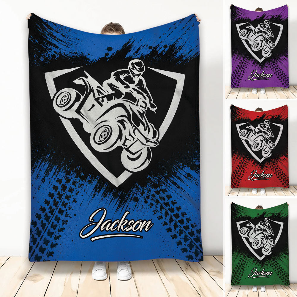 Custom ATV throw blanket with bold quad rider artwork in blue, purple, red, and green color options