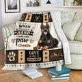 Doberman throw blanket displayed on a sofa with black and tan dog artwork and warm dog lover decor