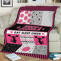 Pink and black cheerleading blanket draped over a sofa with pom-poms, megaphones, stars, and cheerleader silhouettes