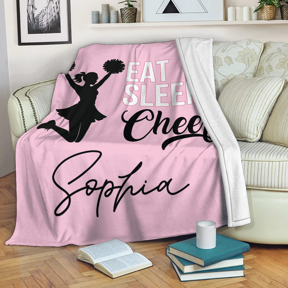 Pink cheerleading blanket draped over a sofa with cheerleader silhouette and bold lettering