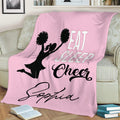 Cheerleading throw blanket displayed on a couch with pink artwork and pom-pom silhouette