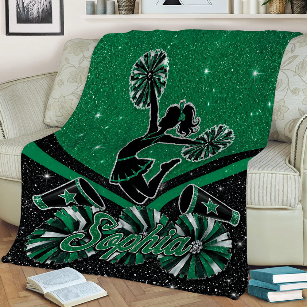 Green cheerleading blanket draped over a sofa with cheerleader silhouette, pom-poms, megaphones, and stars