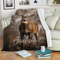 Deer throw blanket draped over a sofa, showcasing a buck and rustic woodland scenery