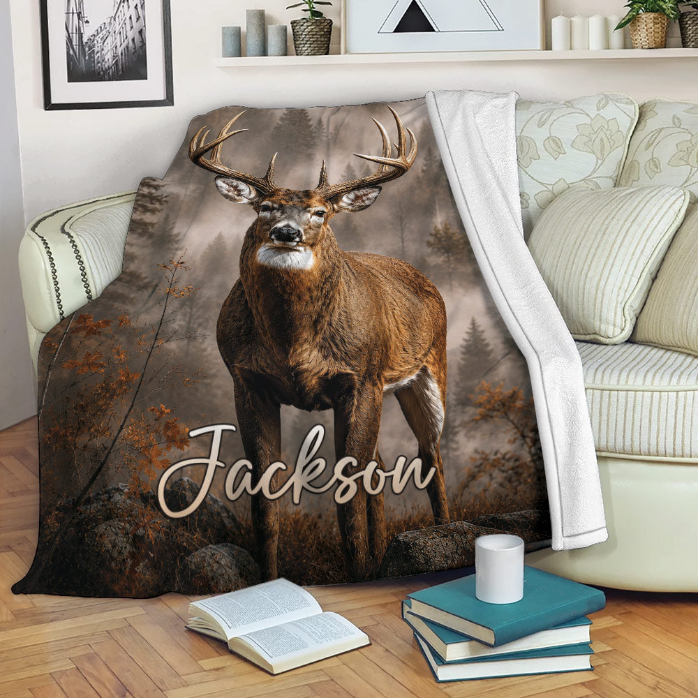 Deer throw blanket draped over a sofa, showcasing a buck and rustic woodland scenery