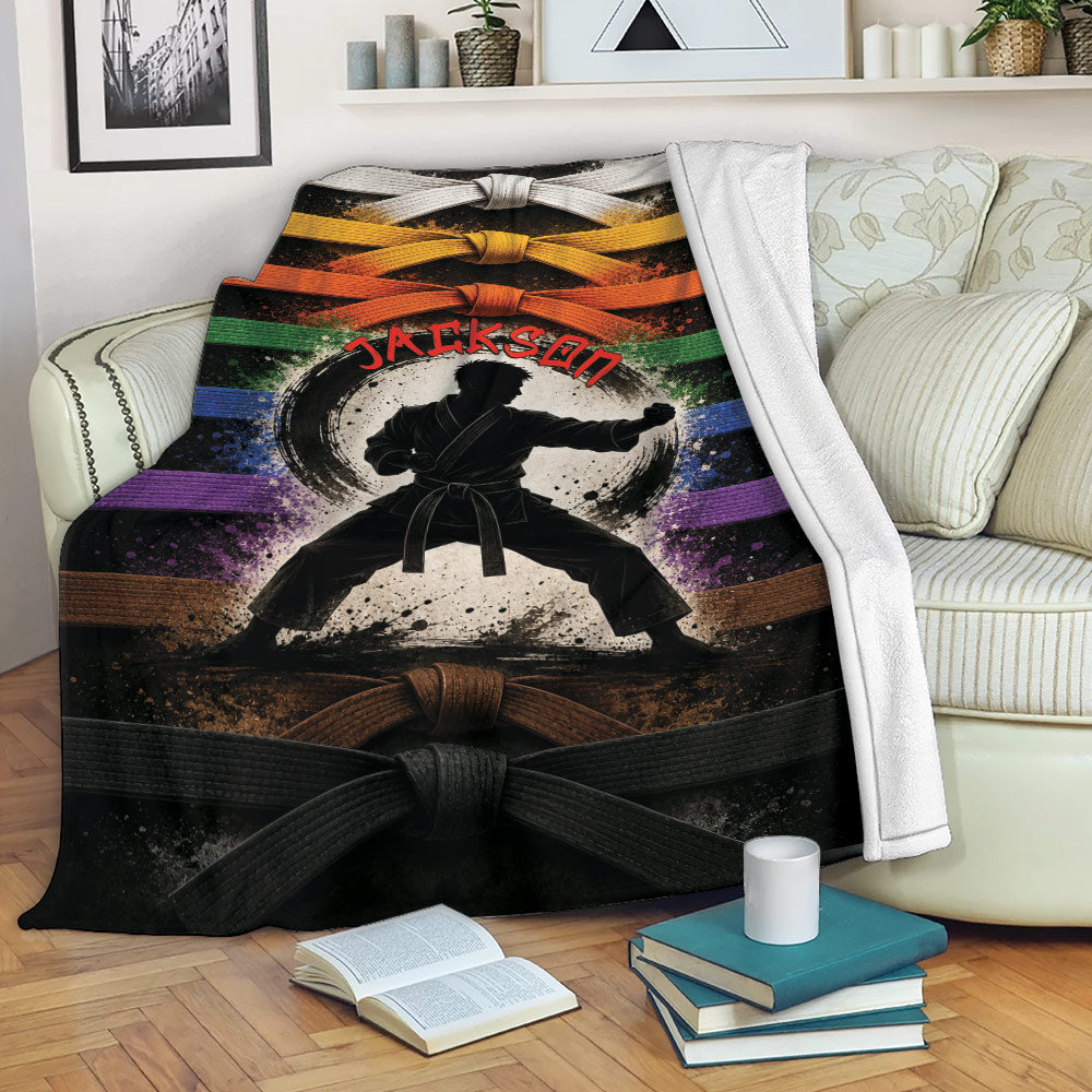Karate blanket displayed on a sofa with martial artist and multicolor belt design