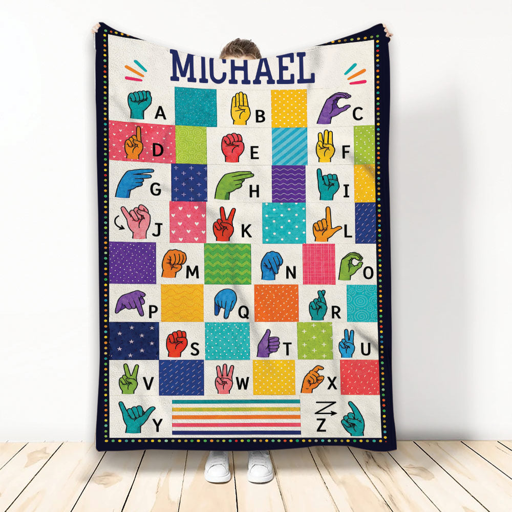 Colorful sign language alphabet blanket with illustrated hand signs and patterned letter panels