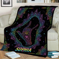 Colorful sign language hand gesture blanket draped over a couch with vibrant mandala design