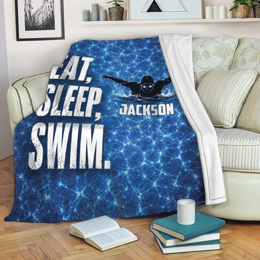 Swimming throw blanket draped over a sofa with blue water artwork and swimmer graphic