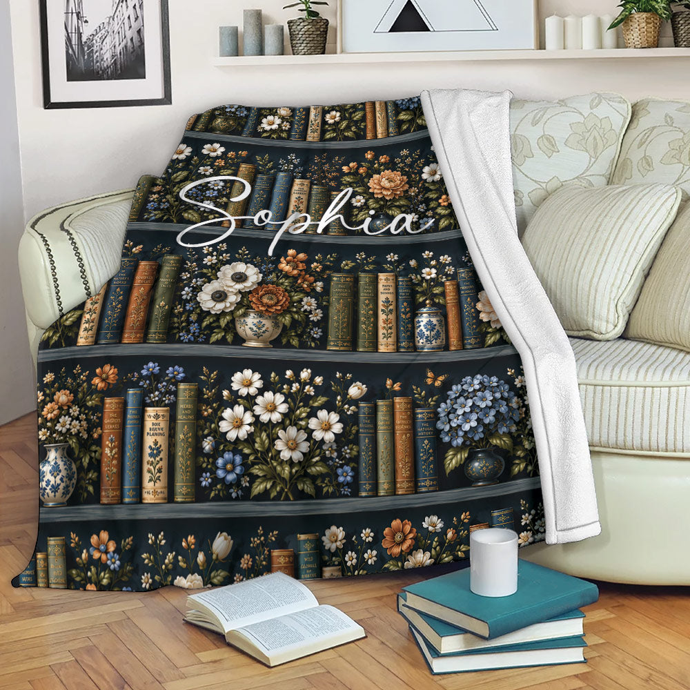 Book lover throw blanket draped over a sofa beside open books and stacked novels