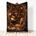 Book-themed throw blanket featuring a glowing library, stacked books, flowers, lanterns, and a reading chair
