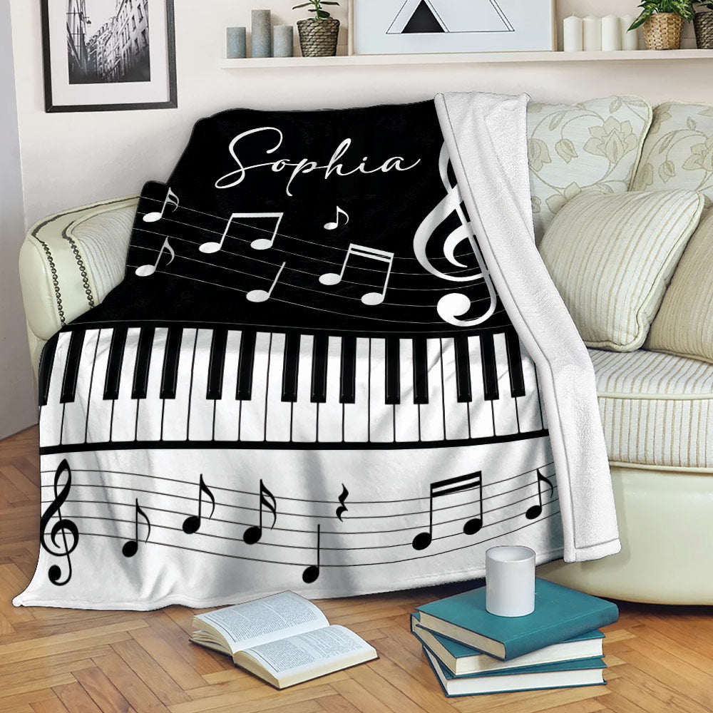 Piano throw blanket draped over a sofa with keyboard keys and musical note artwork