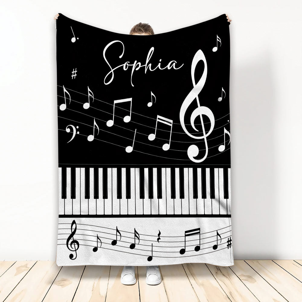 Black and white piano throw blanket with keyboard keys, musical notes, and treble clef artwork