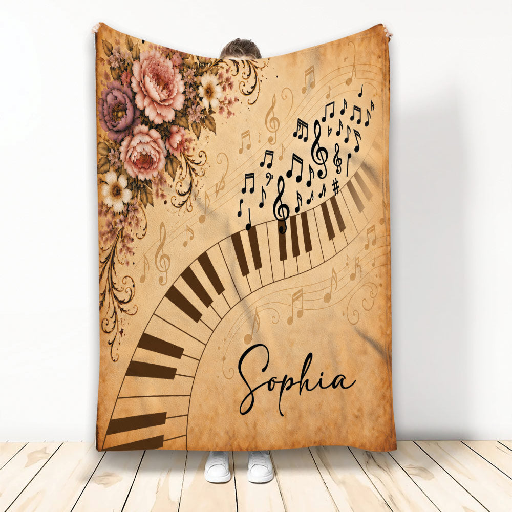 Vintage piano blanket with curved keyboard, musical notes, treble clefs, and ornate floral artwork