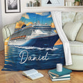 Cruise ship blanket draped over a sofa, showing a ship at sea beneath a colorful sunset sky