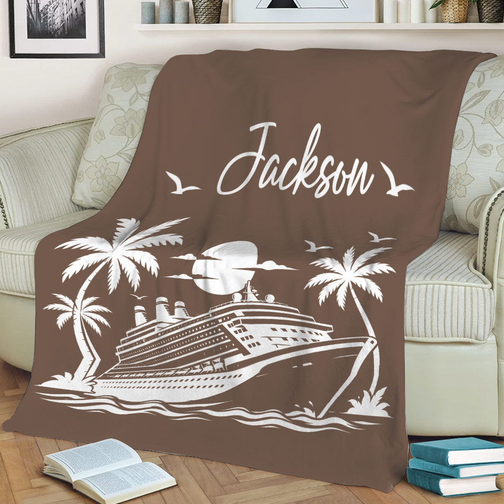 Brown cruise ship blanket displayed on a sofa with tropical palms, waves, and coastal artwork