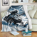 Snowmobile blanket draped over a living room sofa with blue and white mountain riding artwork