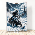 Snowmobile throw blanket featuring a helmeted rider on a mountain trail with snowy peaks and evergreen trees