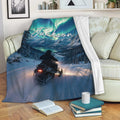 Snowmobile throw blanket draped over a sofa with snowy mountain scenery and aurora artwork
