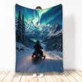 Snowmobile blanket with snowy mountain trail, evergreen trees, lake, and glowing northern lights