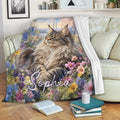 Maine Coon cat throw blanket displayed on a sofa with vibrant meadow flowers and scenic artwork