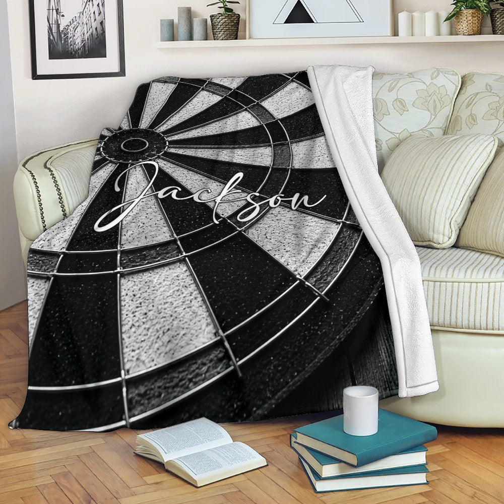 Black and white dart board blanket draped over a cozy living room sofa