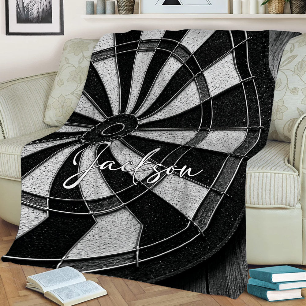 Close view of a black and white dart board blanket styled on a sofa