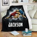 Custom wrestling blanket displayed on a couch with dynamic grappling artwork and a black background