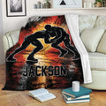 Wrestling blanket displayed on a sofa with dramatic grappling artwork and vivid red and orange colors
