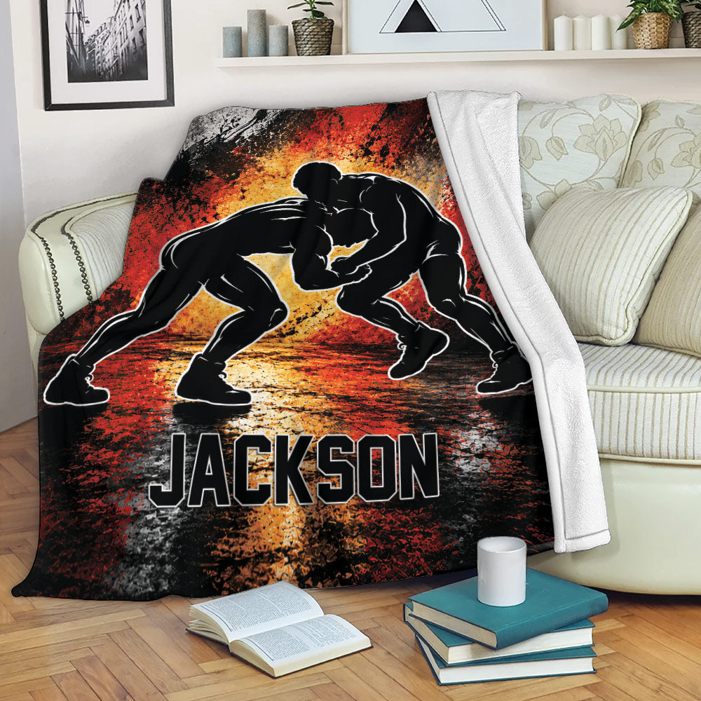 Wrestling blanket displayed on a sofa with dramatic grappling artwork and vivid red and orange colors