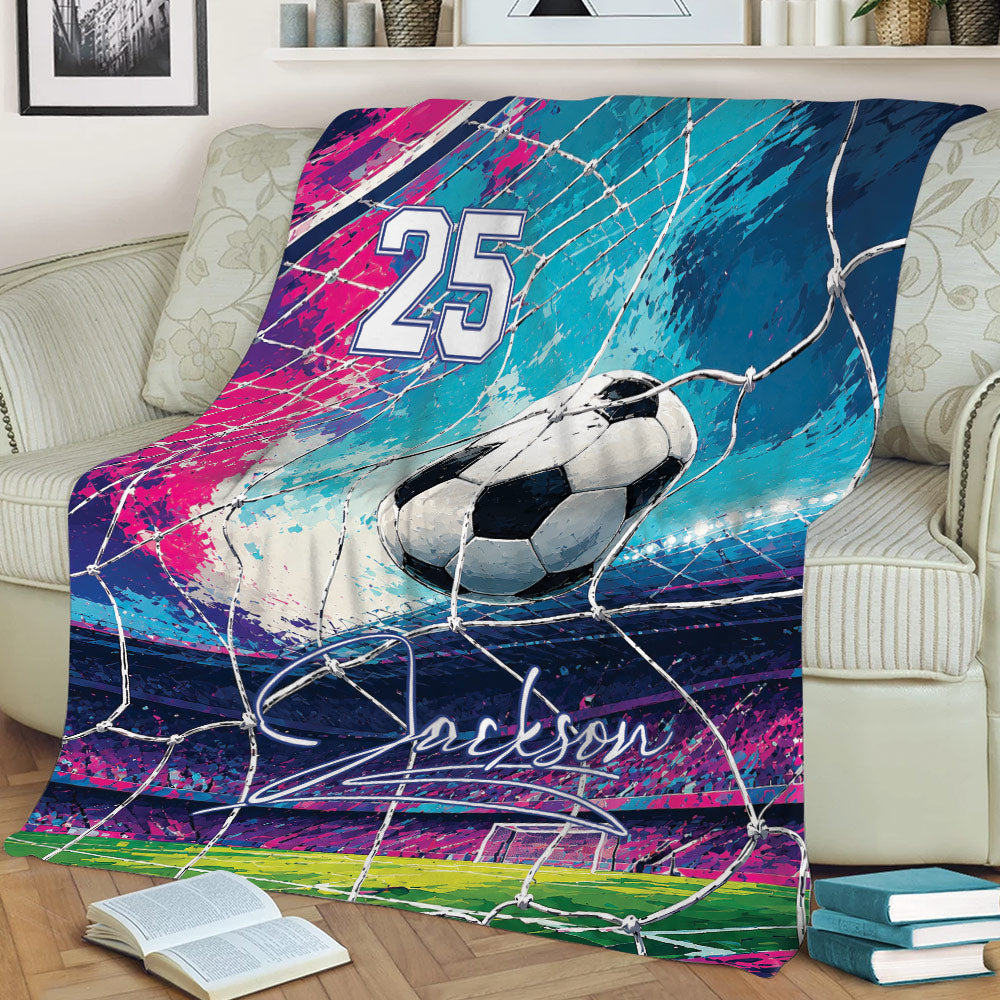 Colorful soccer throw blanket displayed on a couch with ball, goal net, stadium, and vibrant abstract sports artwork