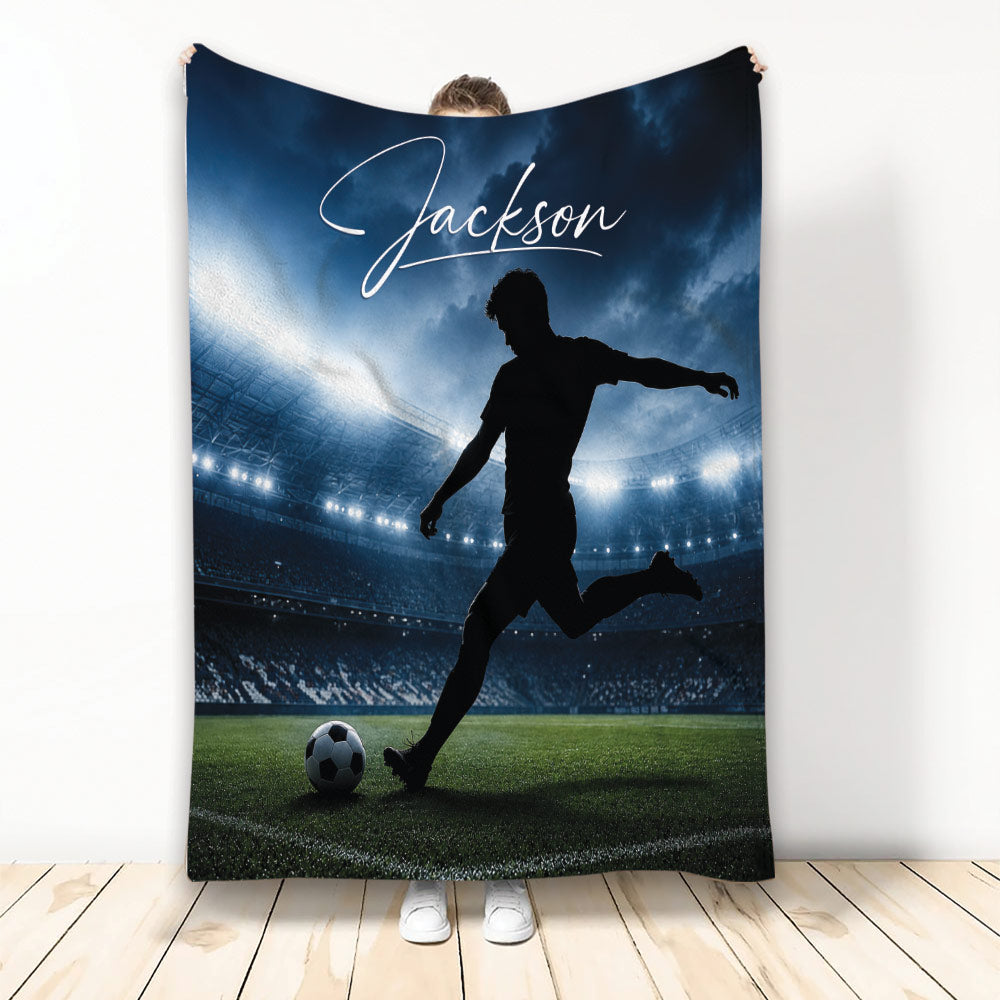 Soccer throw blanket featuring a silhouetted player kicking a ball on a stadium field
