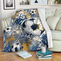 Soccer throw blanket displayed on a sofa with bold illustrated soccer ball artwork