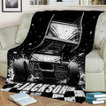 Dirt track racing throw blanket styled on a couch with sprint car artwork, dirt spray, and checkered accents