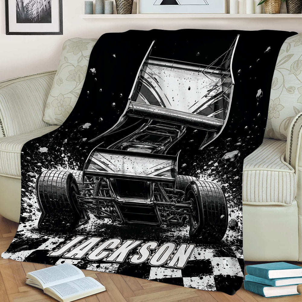 Dirt track racing throw blanket styled on a couch with sprint car artwork, dirt spray, and checkered accents