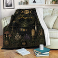 Wicca blanket draped over a sofa with moon phase, crystal, candle and cauldron artwork