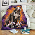 Pitbull blanket draped over a sofa with colorful purple and orange graphic artwork