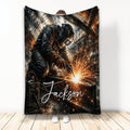 Welder throw blanket displayed upright with protective gear, welding sparks, and industrial workshop artwork