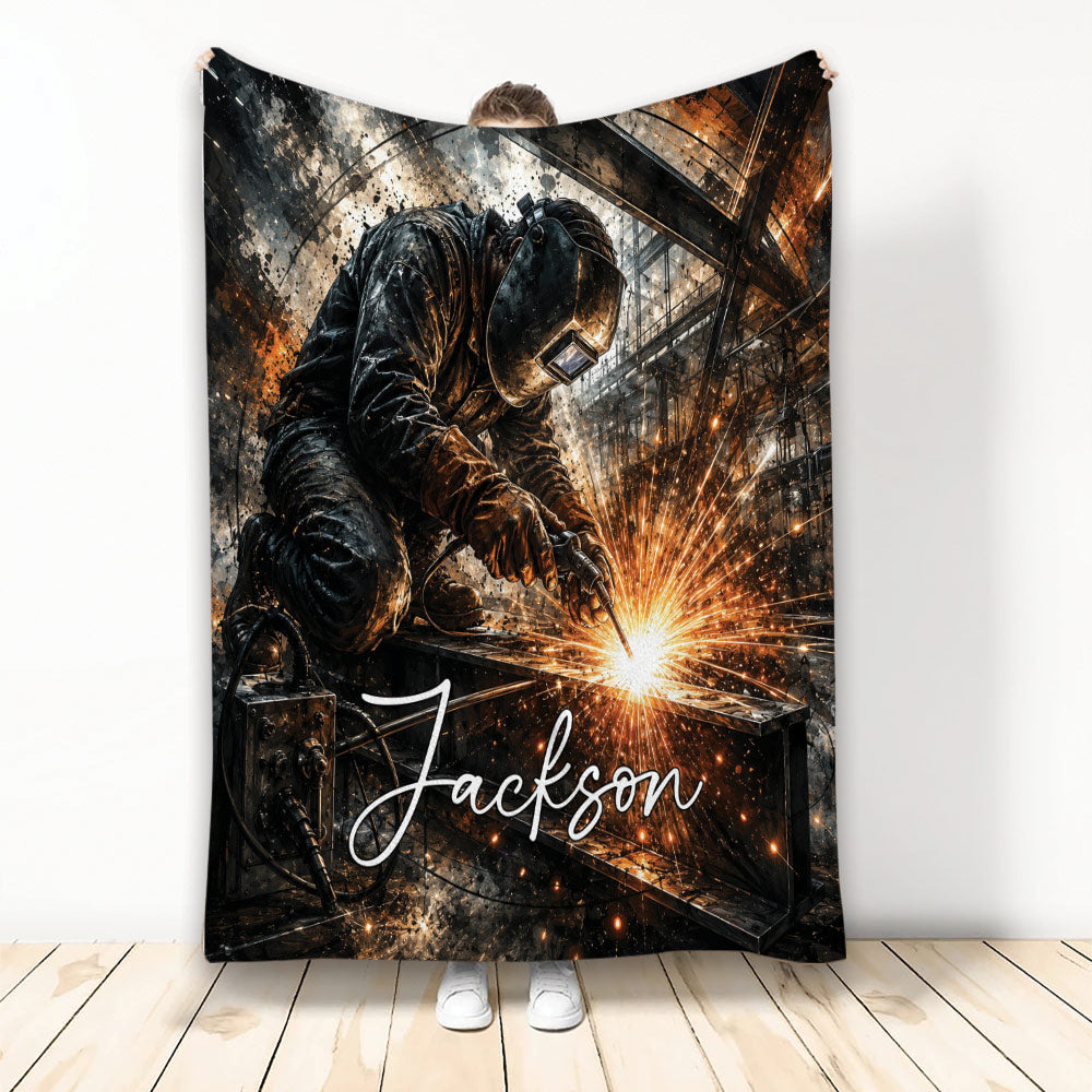 Welder throw blanket displayed upright with protective gear, welding sparks, and industrial workshop artwork