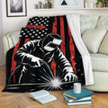 Welder blanket draped over a sofa with patriotic-inspired stars, red stripes, and welding artwork