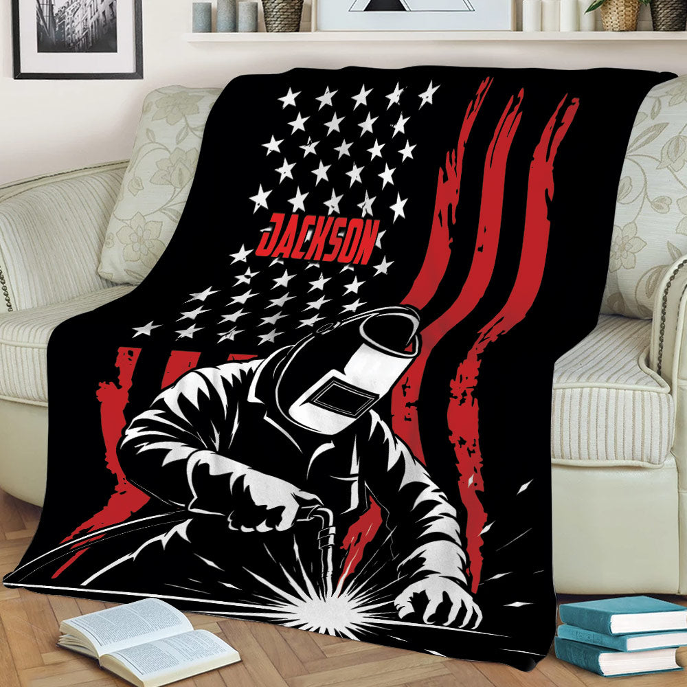 Welder throw blanket displayed on a couch with dramatic welding sparks and bold graphic artwork