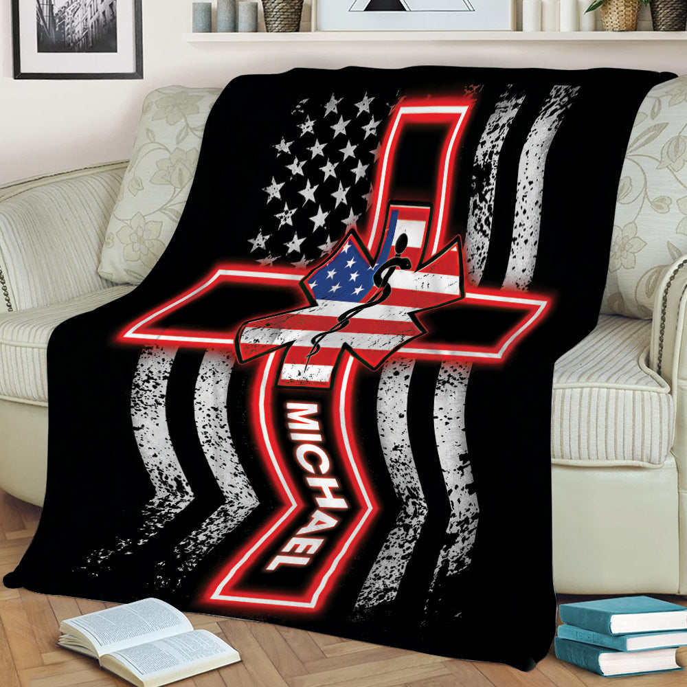 Black paramedic blanket shown on a couch with a red glowing Star of Life and distressed patriotic stripe design