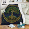 Tree of Life throw blanket displayed on a sofa with green foliage, golden knotwork, and celestial blue artwork