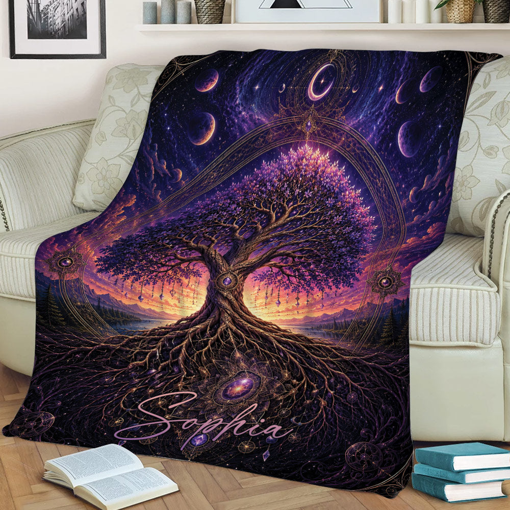 Celestial Tree of Life blanket draped over a couch with glowing roots, moon phases, and purple artwork