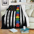 Autism awareness blanket draped over a sofa with colorful puzzle pieces and bold black and white stripes